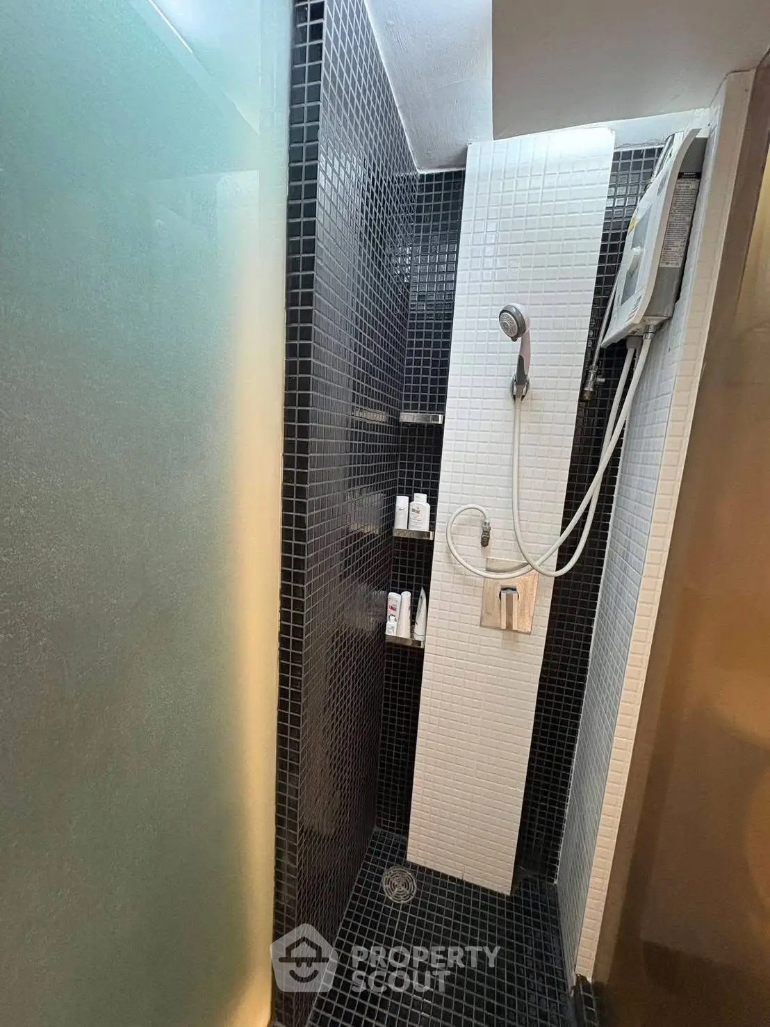 Modern bathroom with sleek black tiles and a glass shower partition