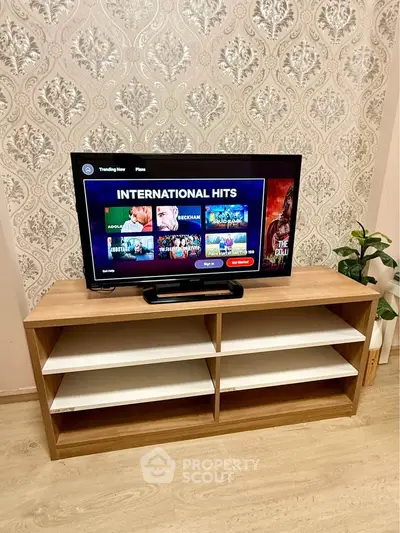 Modern living room with stylish TV stand and flat-screen TV displaying international hits.