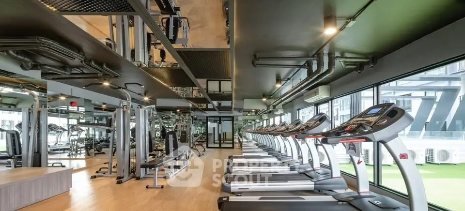 Modern gym with state-of-the-art equipment and large windows in a luxury residential building.