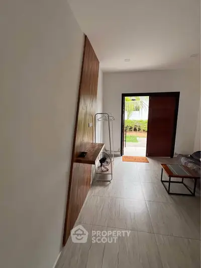 Modern living room with open door to garden, featuring sleek furniture and stylish decor.