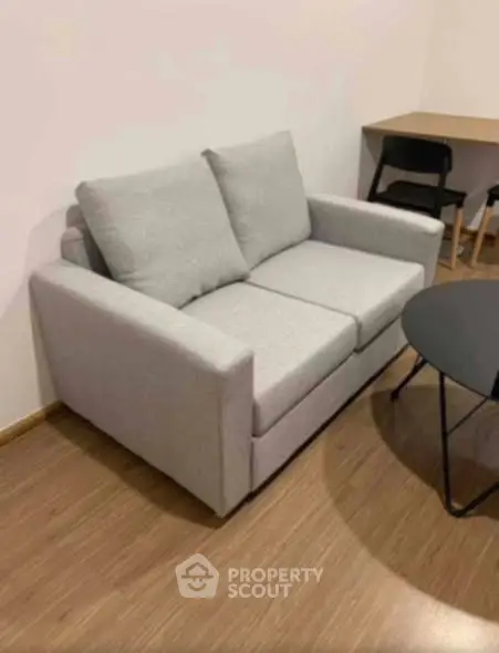 Cozy living room with modern gray sofa and stylish round coffee table.