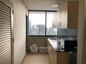 Compact kitchen with city view, featuring modern cabinetry and sleek countertops.