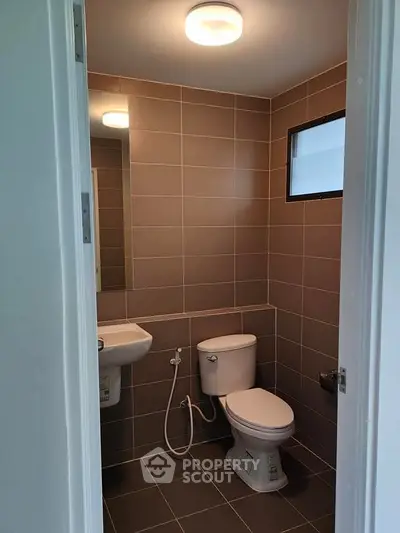 Modern bathroom with sleek brown tiles and compact design