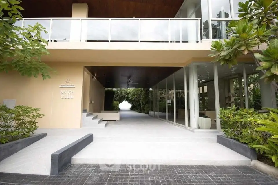 Modern beach club entrance with sleek design and lush greenery