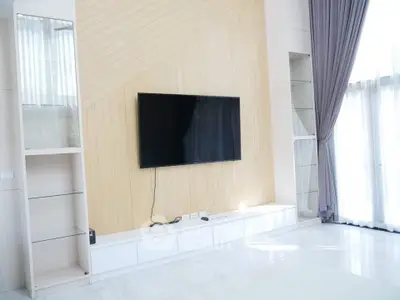 Spacious modern living room with large TV and elegant curtains