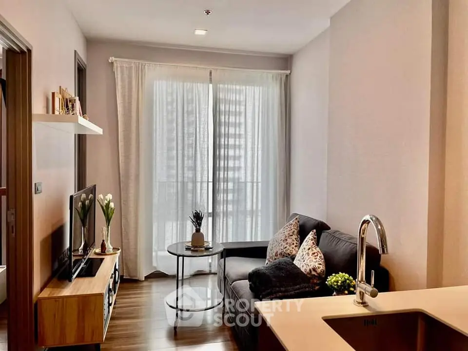 Modern living room with cozy sofa, stylish decor, and natural light from large window.