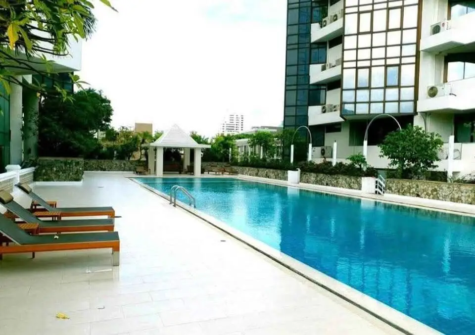 Luxurious apartment complex with a stunning outdoor pool and modern architecture.