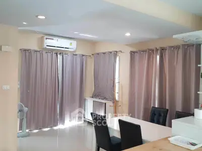 Spacious living room with modern dining area and ample natural light