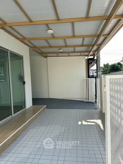 Spacious covered balcony with modern tiles and sliding glass doors