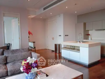 Modern living room with open kitchen, elegant decor, and hardwood floors in a luxurious apartment.