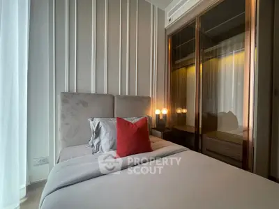 Modern bedroom with elegant decor and plush bedding in a stylish apartment.