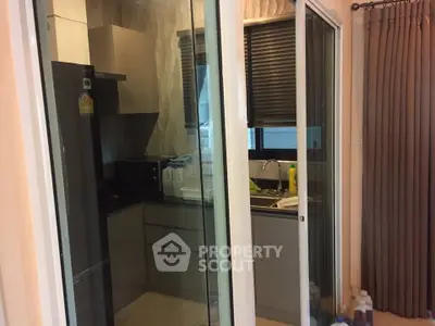 Modern kitchen with sleek cabinetry and sliding glass doors in a stylish apartment.