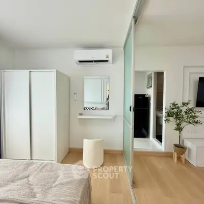 Modern bedroom with sliding glass doors, air conditioning, and minimalist decor.