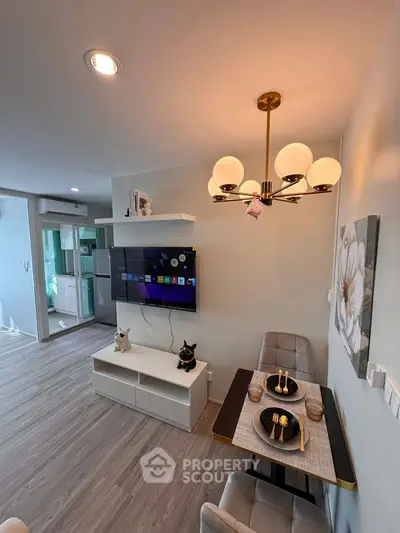 Modern living room with stylish decor and dining area, featuring a wall-mounted TV and elegant lighting.