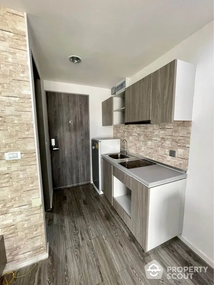 Modern compact kitchen with sleek cabinetry and wood accents