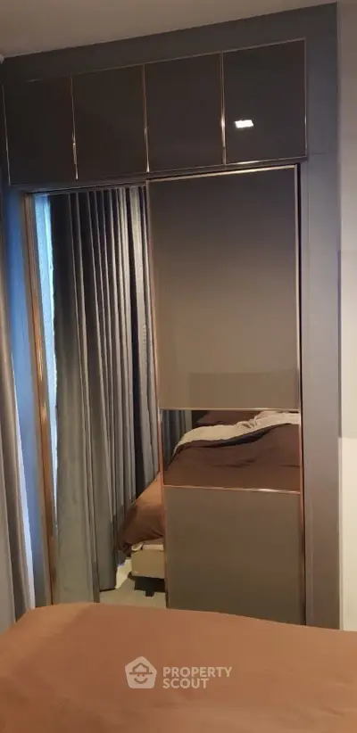 Modern bedroom with sleek built-in wardrobe and luxurious curtains.