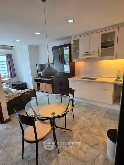 Modern open-layout kitchen and dining area with stylish lighting and marble flooring.