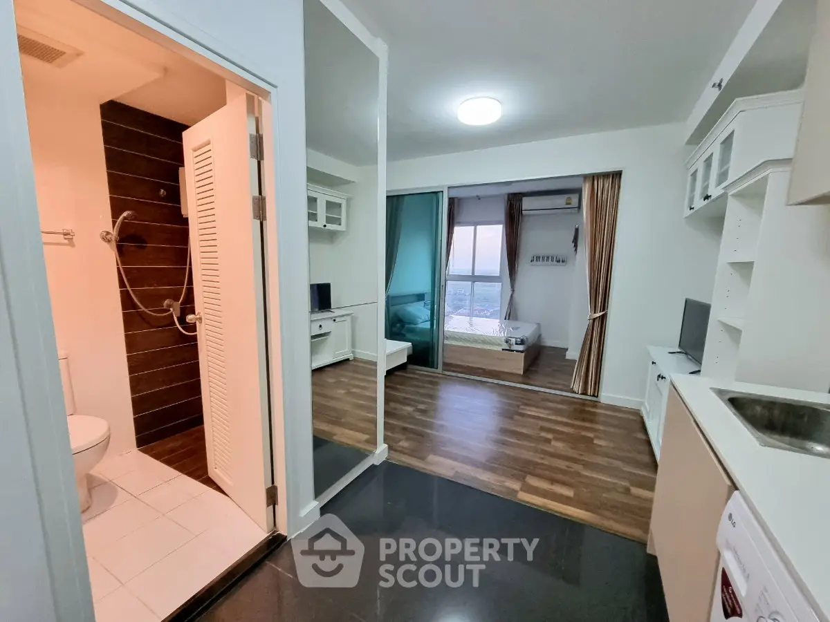 Modern apartment interior with open layout, featuring a cozy bedroom, sleek kitchen, and stylish bathroom.