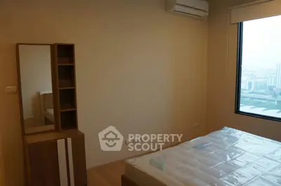 Modern bedroom with city view, featuring a sleek air conditioner and stylish furniture.