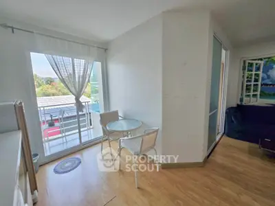 Charming apartment with cozy dining area and balcony view, perfect for relaxation and enjoying natural light.