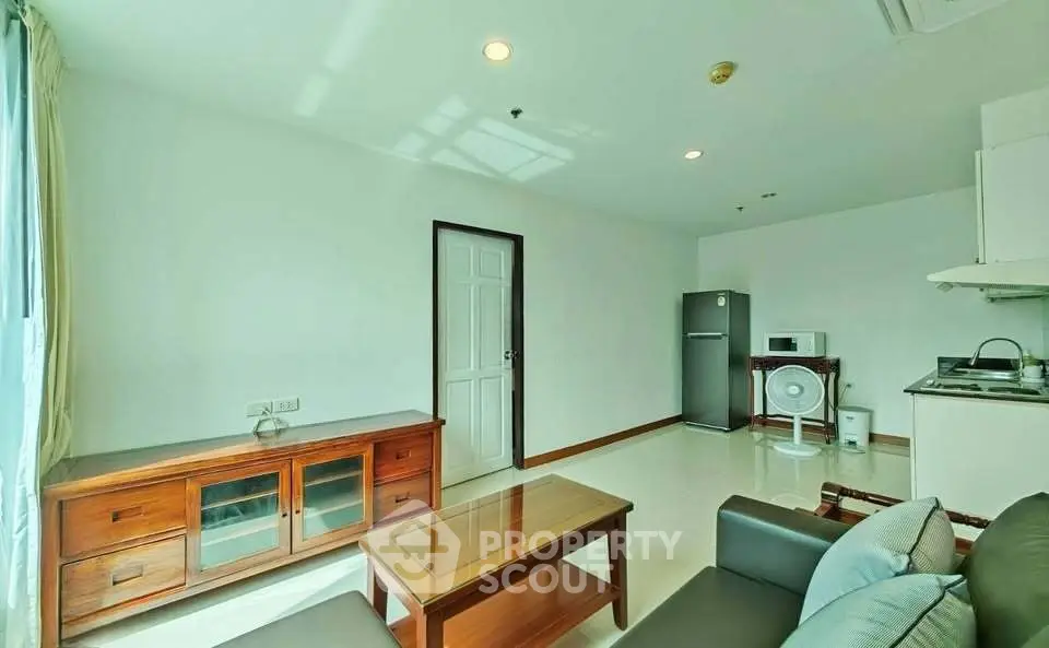 Bright and cozy living room with modern furniture and kitchen area, perfect for urban living.