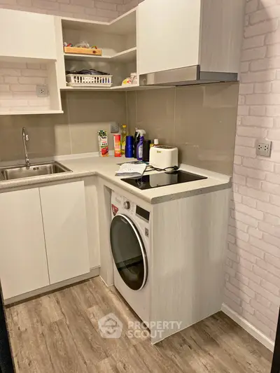 Modern compact kitchen with washing machine and sleek cabinetry