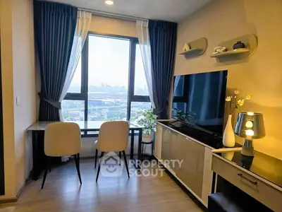Modern living room with large window and city view, featuring stylish decor and seating area.