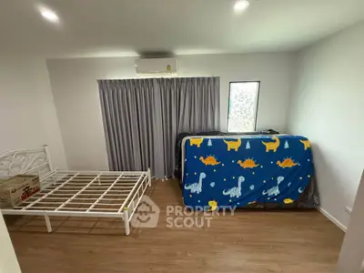 Spacious bedroom with wooden flooring and large window, featuring a bed frame and air conditioning.