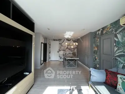 Stylish living room with modern decor and vibrant wallpaper, featuring a cozy seating area and sleek TV unit.