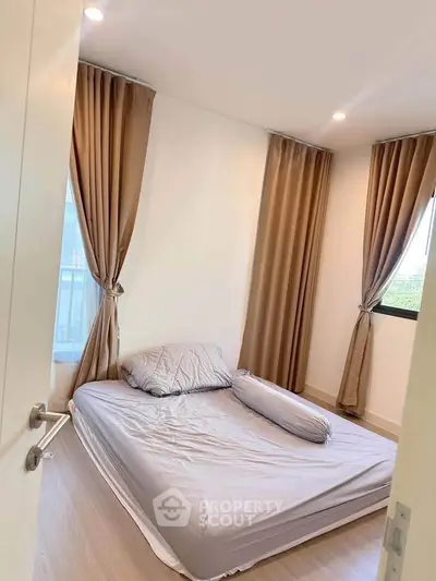 Cozy bedroom with natural light and elegant curtains, perfect for relaxation.