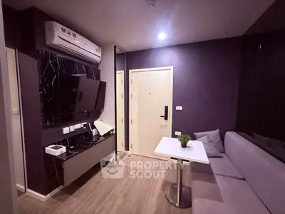 Modern living room with sleek design, featuring a wall-mounted TV, air conditioning, and stylish furniture.