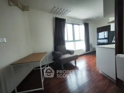 Modern living room with wooden flooring and large window in a cozy apartment.