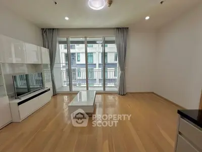 Spacious modern living room with large windows and wooden flooring