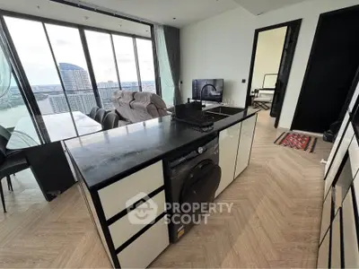 Modern open-plan living room with stunning city view and sleek kitchen island.