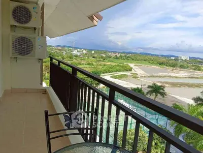 Spacious balcony with scenic view of lush greenery and distant mountains.