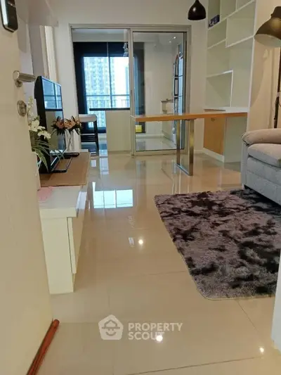 Modern living room with sleek tile flooring and cozy rug, featuring a balcony view.