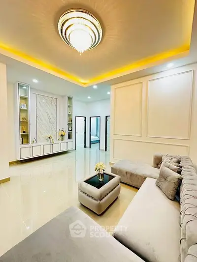 Luxurious living room with elegant chandelier and plush gray sectional sofa