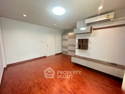 Spacious unfurnished room with wooden flooring and modern air conditioning unit.
