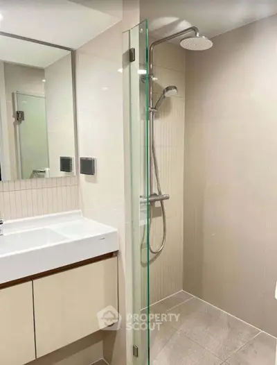 Modern bathroom with sleek shower and elegant vanity in contemporary apartment.