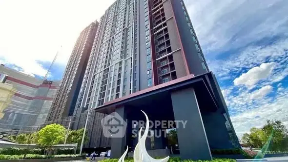 Modern high-rise building with sleek design and lush surroundings, perfect for urban living.