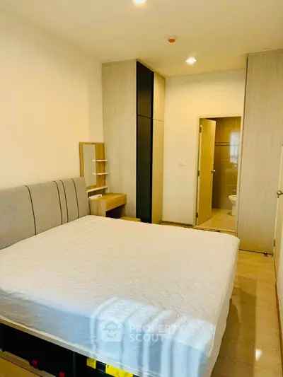 Modern bedroom with ensuite bathroom and stylish furnishings in a cozy apartment.