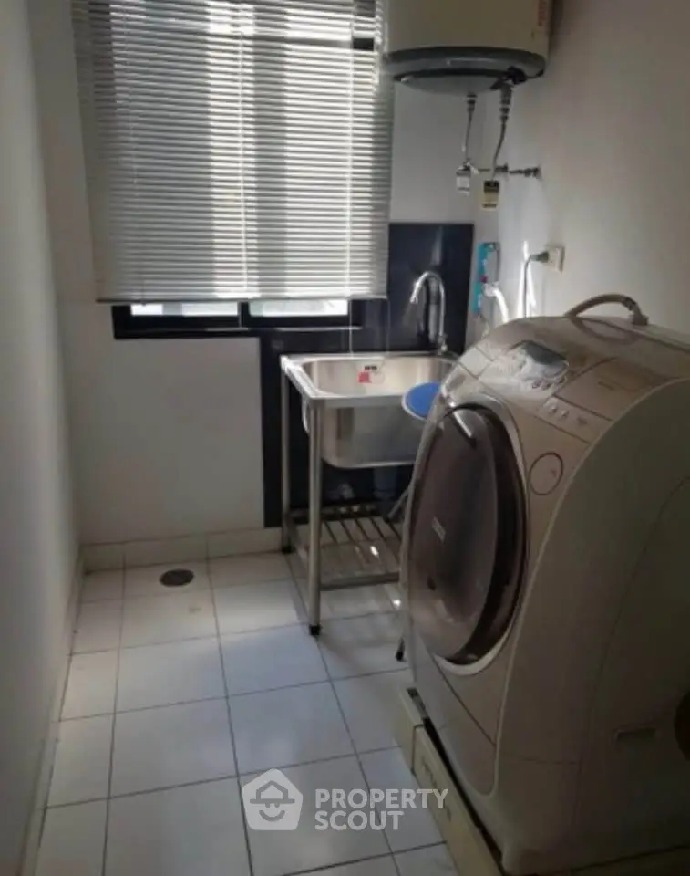 Compact laundry room with washing machine and sink, ideal for efficient home living.