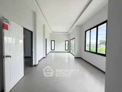 Spacious modern living room with large windows and natural light