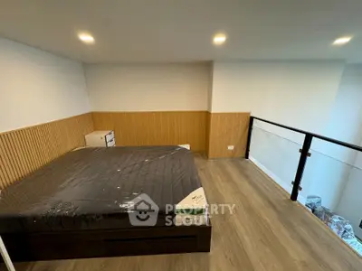 Modern loft bedroom with wooden flooring and glass railing