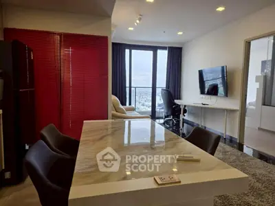 Modern open-plan living room with city view, featuring sleek furniture and a marble dining table.