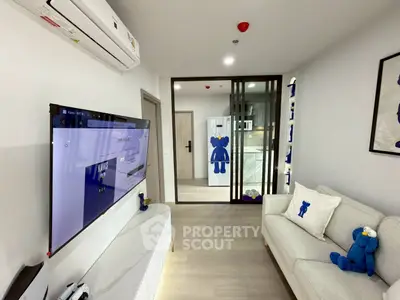 Modern living room with stylish decor and large TV, featuring plush seating and air conditioning.