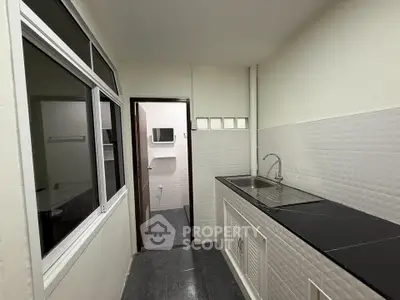 Modern kitchen with sleek black countertop and stainless steel sink, featuring a closed layout design.