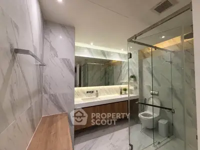 Luxurious modern bathroom with marble walls and glass shower enclosure