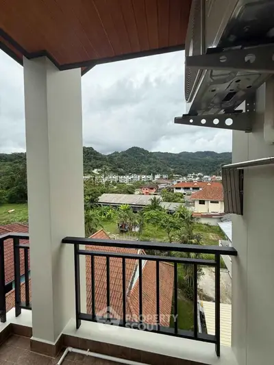 Stunning balcony view overlooking lush greenery and distant mountains, perfect for relaxation and enjoying nature.