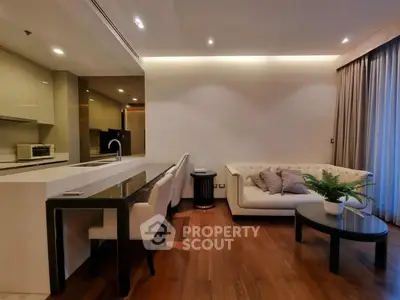 Modern living room with open kitchen, elegant sofa, and stylish decor.